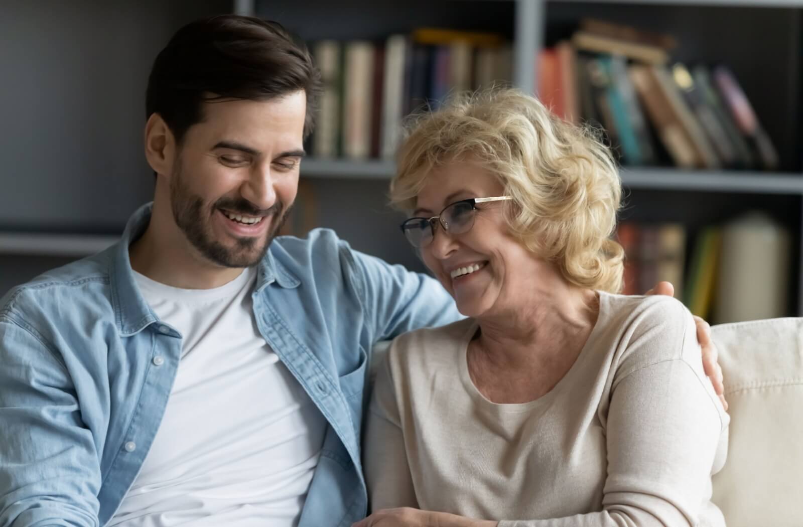 A person sits with their senior parent during a visit to respite care.