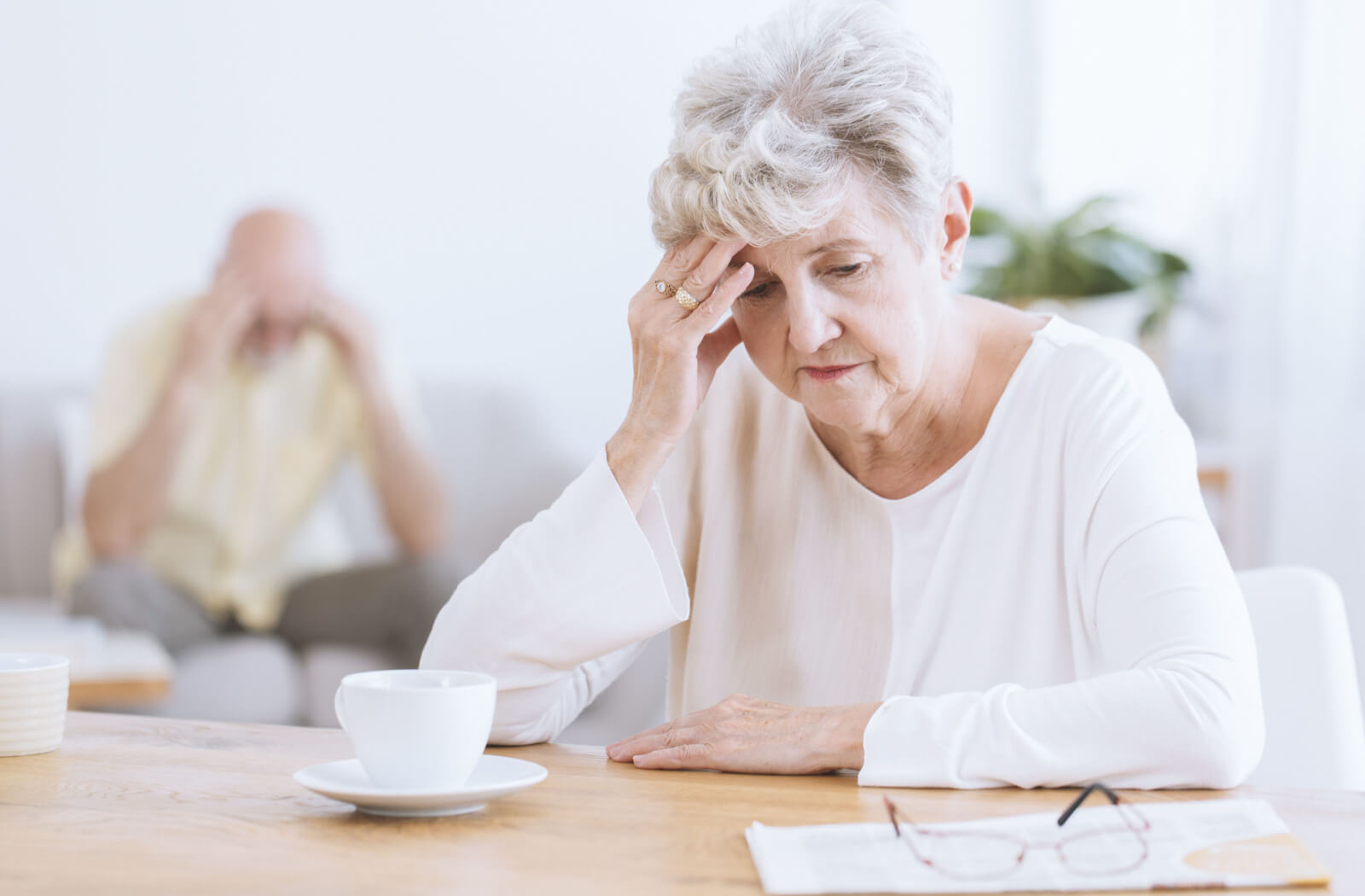 A group of older adults in memory care work together to assemble a white puzzle while laughing
